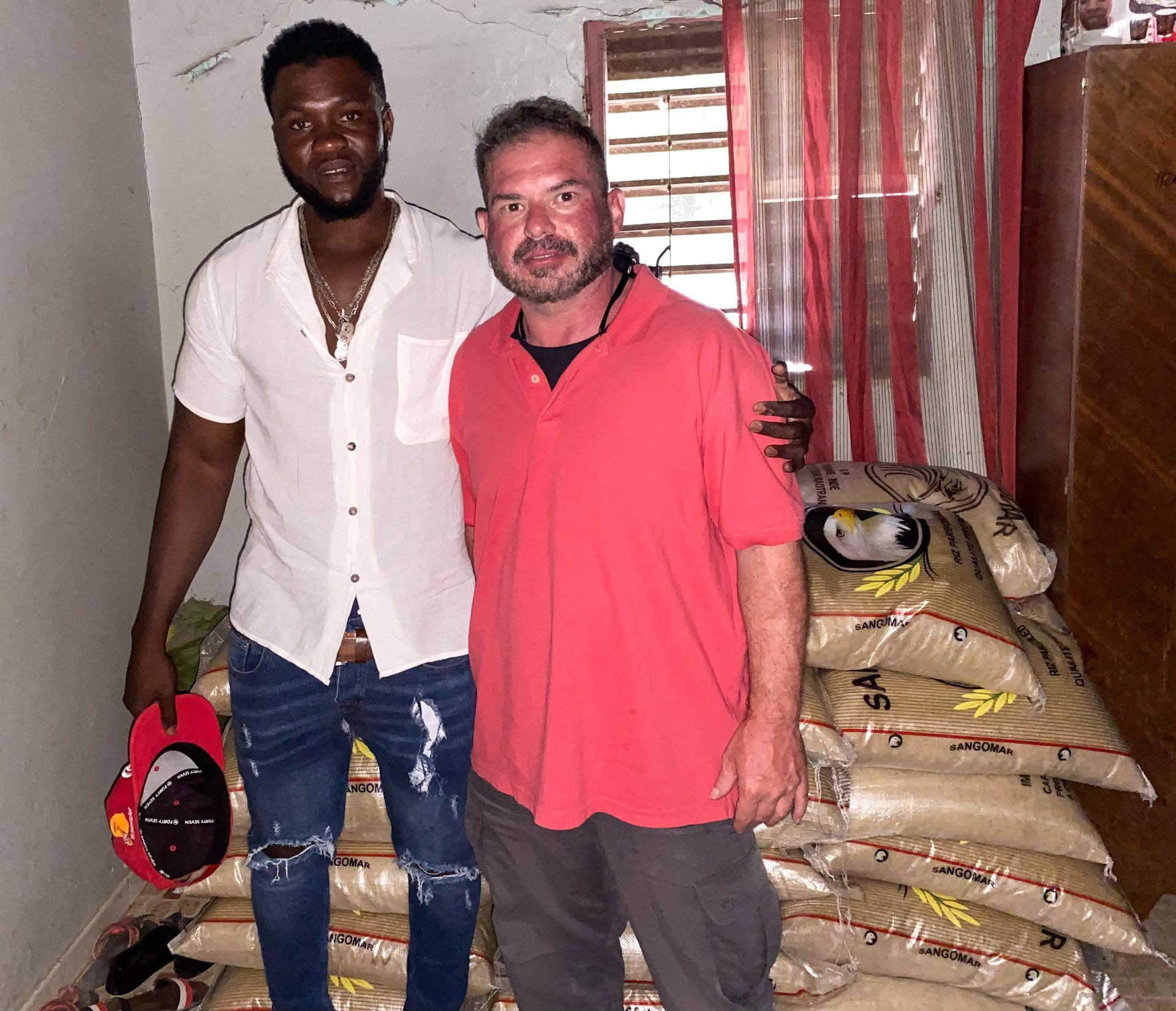 Missionaries with local community partner in Senegal standing beside rice donations for famine relief, part of Africa 1040 Global Ministries’ outreach to serve the poor and share the gospel in West Africa.